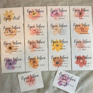 May include: A set of 15 cards with watercolor floral designs and the text "Open When" followed by a phrase. The phrases include "You're Happy", "You Need a Prayer", "You Want to Hear a Joke", "You Need Motivation", "You're Hungry", "You Need a Bible Verse", "You're Sad", "You're Bored", "You Want a Look Into the Future", "You Can't Sleep", "You're Stressed", "You Need to Make a Tough Decision", "You're Having a Good Day", "You Will Walk Down Memory Lane", "You Need Inspiration".