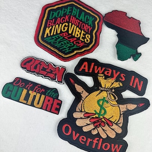 May include: Embroidered patches with various designs and text. One patch reads "DOPE BLACK BLACK HISTORY KING VIBES EVERY MONTH". Another patch features the African continent in red, black, and green.