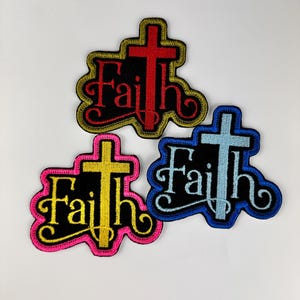 May include: Three embroidered iron-on patches with a cross and the word "Faith" in a stylized font. The patches are in red, blue, and yellow with black outlines.