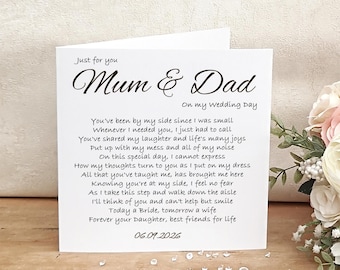 May include: A white wedding card with the text "Mum & Dad" in elegant script, along with a heartfelt poem. The card is adorned with floral accents and the date 06.09.2026. A touching keepsake for parents on a special day.