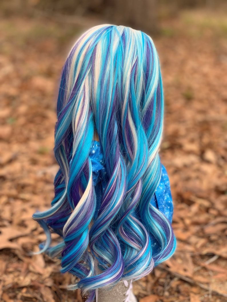 May include: A long, curly wig with streaks of blue, purple, and white.