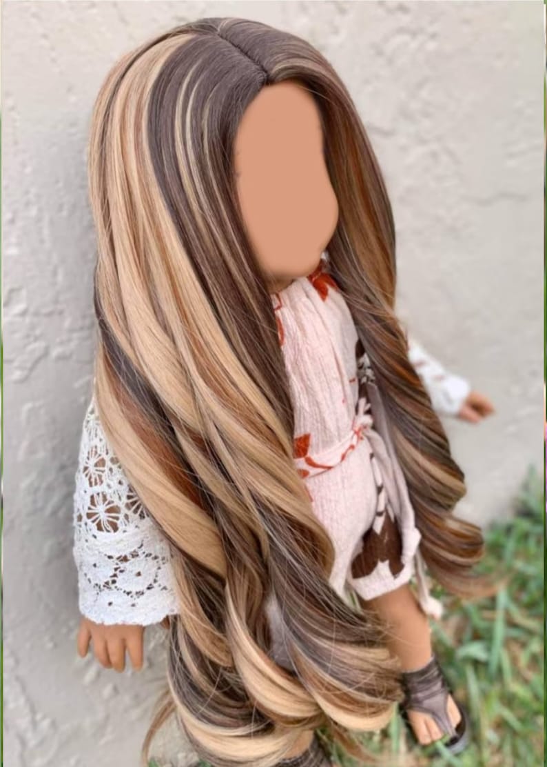 May include: A long, wavy doll wig with brown, blonde, and light brown streaks. The wig is styled in a side part and has a natural, flowing look.