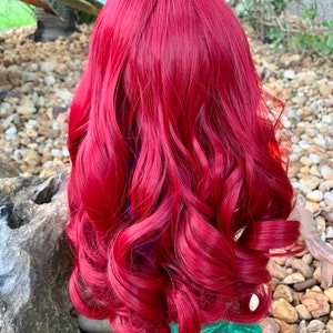 Puede incluir: Una peluca larga, rizada y roja con ondas sueltas. La peluca est&aacute; peinada de una manera que se asemeja al cabello de una sirena.