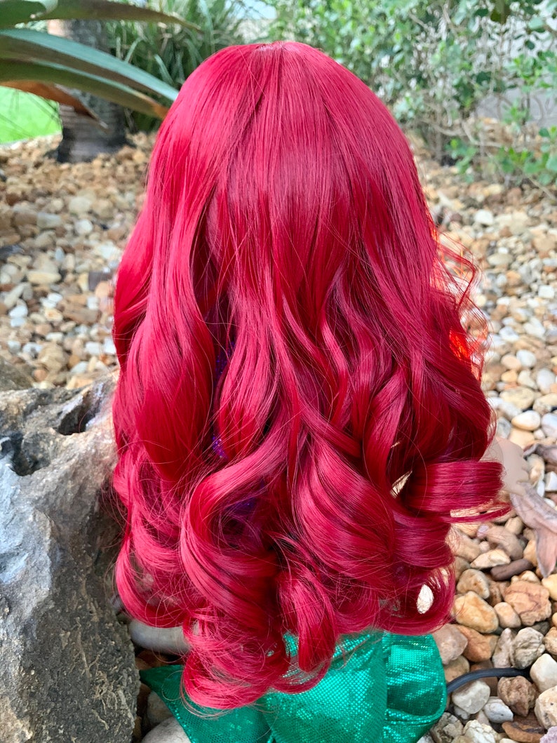 Puede incluir: Una peluca larga, rizada y roja con ondas sueltas. La peluca est&aacute; peinada de una manera que se asemeja al cabello de una sirena.