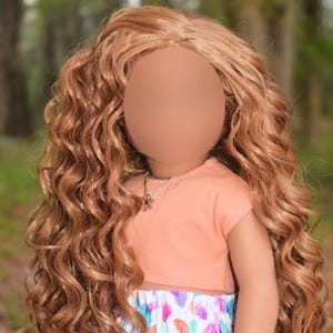 K&ouml;nnte beinhalten: Eine Puppe mit langem, welligem, hellbraunem Haar tr&auml;gt ein pfirsichfarbenes Kurzarm-Oberteil und einen wei&szlig;en Rock mit einem bunten abstrakten Muster aus rosa, blauen und orangefarbenen Formen. Die Puppe tr&auml;gt eine silberfarbene Kette und ein Perlenarmband.