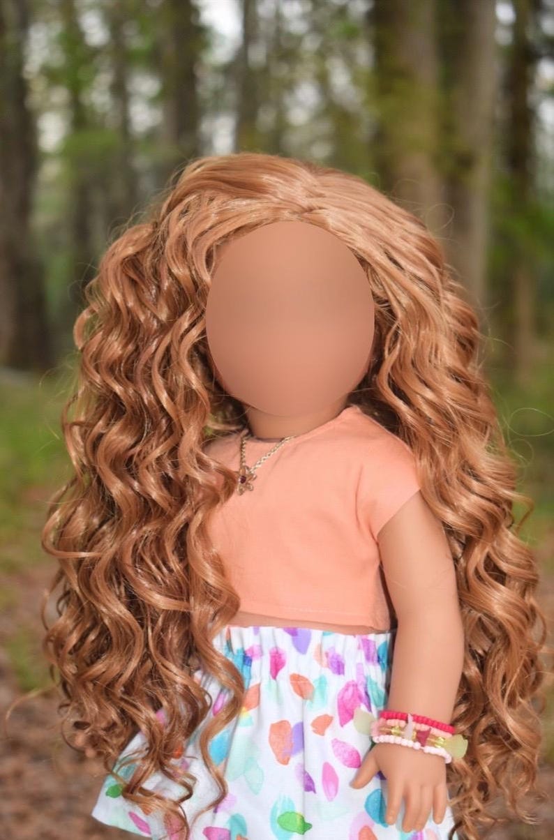 K&ouml;nnte beinhalten: Eine Puppe mit langem, welligem, hellbraunem Haar tr&auml;gt ein pfirsichfarbenes Kurzarm-Oberteil und einen wei&szlig;en Rock mit einem bunten abstrakten Muster aus rosa, blauen und orangefarbenen Formen. Die Puppe tr&auml;gt eine silberfarbene Kette und ein Perlenarmband.