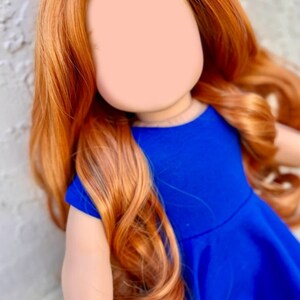 May include: A doll with long, wavy, auburn hair wearing a royal blue dress.