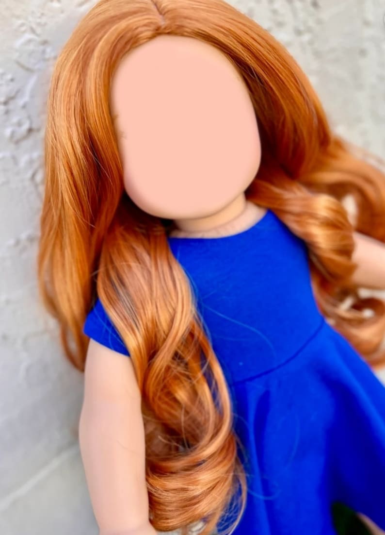 May include: A doll with long, wavy, auburn hair wearing a royal blue dress.