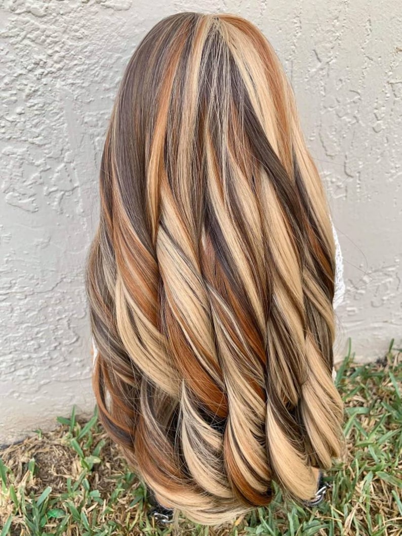 May include: Long, wavy hair with highlights in shades of brown, blonde, and copper.