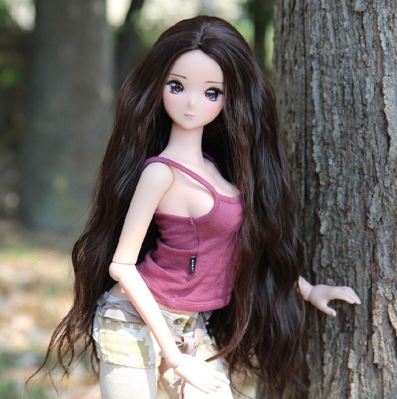 May include: A doll with long, dark brown hair wearing a pink tank top and a pair of camouflage shorts.