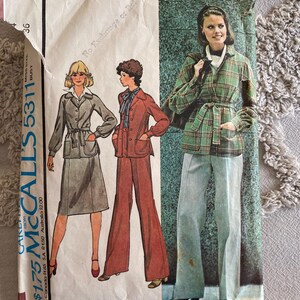 May include: Vintage McCall's sewing pattern envelope with illustrations of women's clothing. The envelope shows a shirt-jacket, skirt, and trousers ensemble. The price is £1.75. The pattern number is 5311.