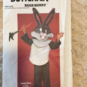 May include: A vintage sewing pattern for a Bugs Bunny costume. The pattern is from the company Butterick and is for a one-size costume. The pattern includes a picture of a child wearing the costume.