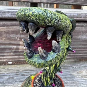 May include: A handmade, wooden cutting board with a natural finish. The board features a juice groove and a handle. Dimensions: 18 inches long, 12 inches wide, and 1 inch thick.