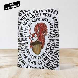 May include: A5 notebook with a whimsical illustration of a red squirrel holding an acorn. The cover features the words "NOTES" and "NUTS" in a circular pattern. The top left corner has a black rectangle with the text "A5 NOTEBOOK".