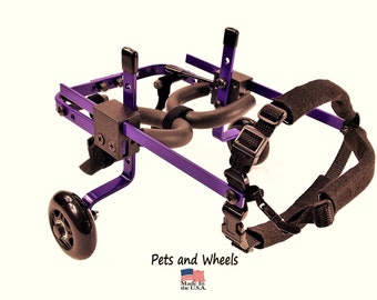 May include: Purple dog wheelchair with black wheels and adjustable straps.  "Pets and Wheels" and "Made in the U.S.A." are printed on the wheelchair.