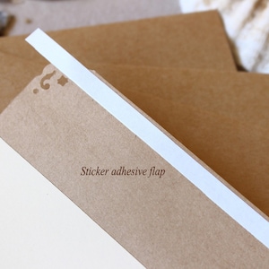 Puede incluir: Un sobre de papel marr&oacute;n con una solapa adhesiva blanca. El sobre tiene un dise&ntilde;o decorativo de corte en la parte delantera.