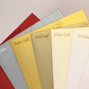 May include: A close-up of eight different colored cardstock samples. The colors are red lacquer, silver, super gold, gold leaf, white gold, ice gold, and ice silver.