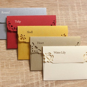 May include: Five decorative envelopes with different colors and cut-out designs. The envelopes are labeled "Round", "Tulip", "Shell", "Heart", and "Water Lily".