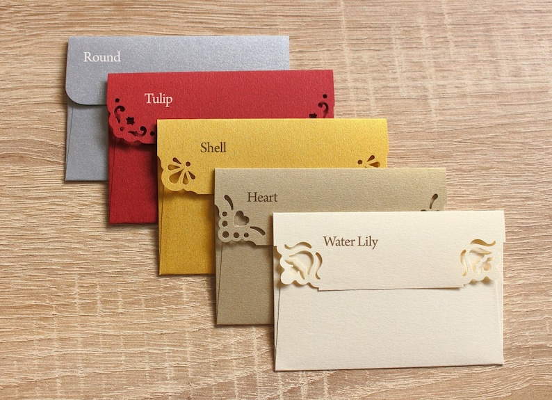 May include: Five decorative envelopes with different colors and cut-out designs. The envelopes are labeled "Round", "Tulip", "Shell", "Heart", and "Water Lily".