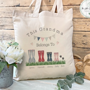 May include: A white canvas tote bag with the text "This Grandma Belongs To" and a row of colourful rain boots with names below them. The text "The Little Green Shed Personalised Gifts" is in the top right corner.