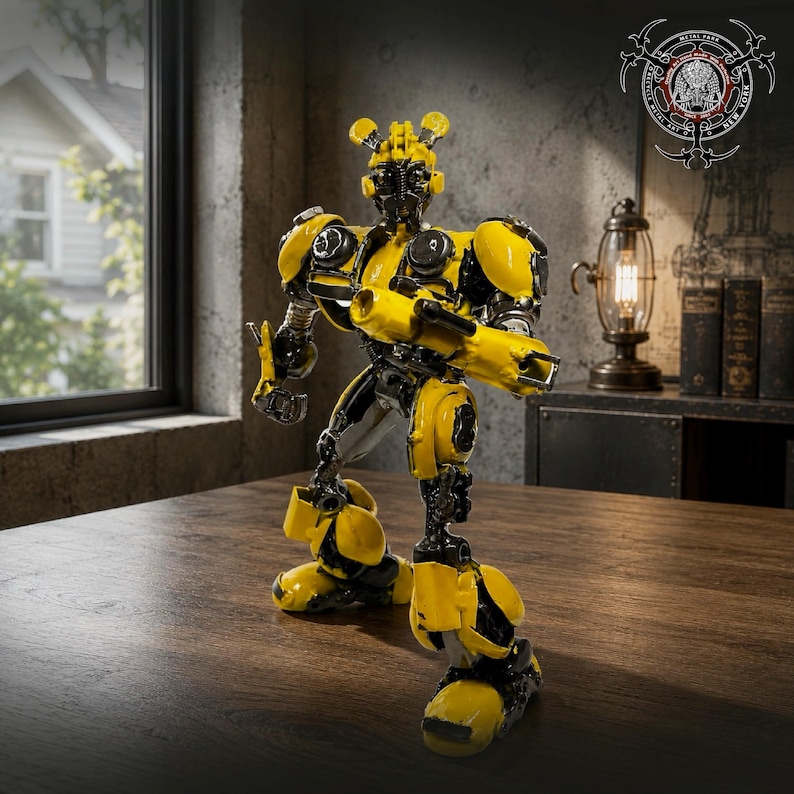 May include: A yellow and black robot figurine constructed from recycled metal parts. The robot features a rounded head with antennae, shoulder armour, and a cannon-like attachment on one arm. It stands in a bipedal pose with articulated joints.