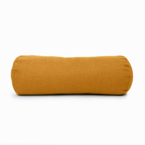 May include: A mustard yellow cylindrical pillow with a linen fabric cover.