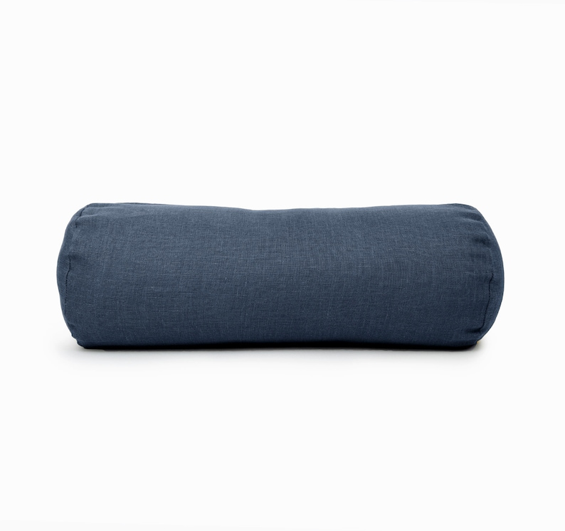 May include: A blue cylindrical cushion made from a textured fabric. The cushion is perfect for adding a touch of comfort and style to any room.