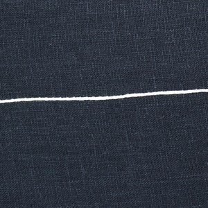 K&ouml;nnte beinhalten: Nahaufnahme eines dunkelblauen Stoffes mit einer einzigen wei&szlig;en Linie, die horizontal durch die Mitte verl&auml;uft.