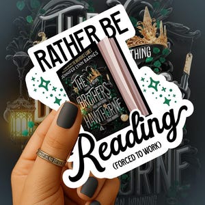 Puede incluir: Una pegatina con el texto "Rather Be Reading (Forced to Work)" sobre la portada de un libro. El libro se titula "The Brothers Hawthorne" de Jennifer Lynn Barnes. El fondo presenta una corona y otros elementos decorativos.