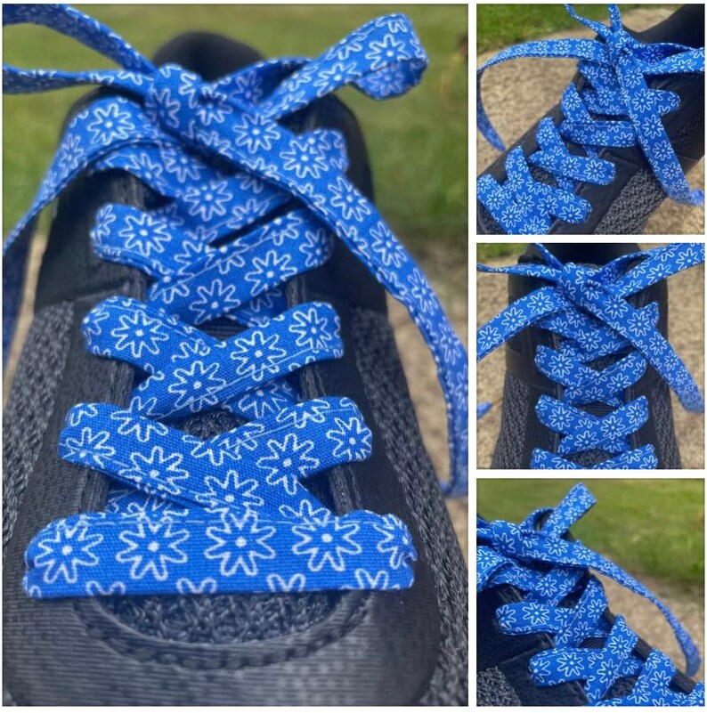 May include: Close-up of a black athletic shoe with bright blue shoelaces. The shoelaces are patterned with white floral designs. The laces are tied in a crisscross pattern.