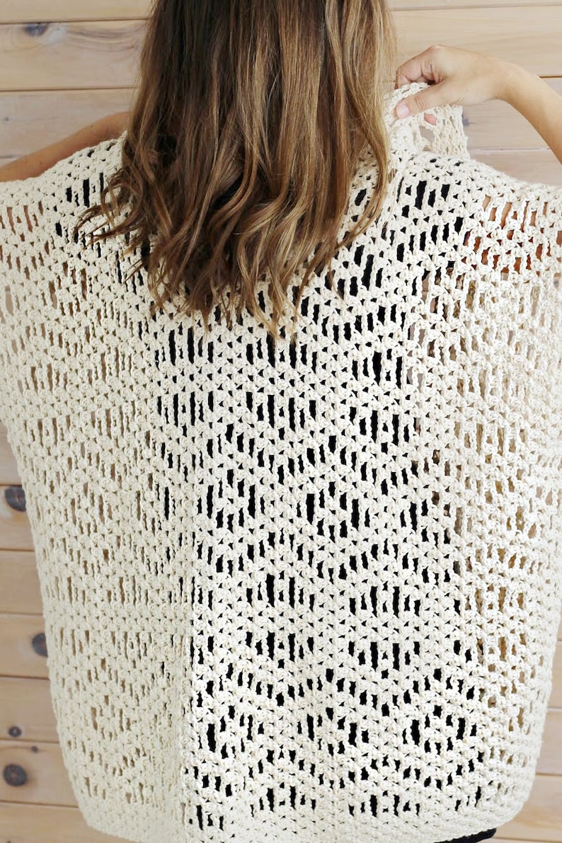 May include: A crocheted top with a delicate openwork pattern in a cream color.