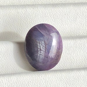 May include: A purple oval-shaped gemstone with a star-like pattern.