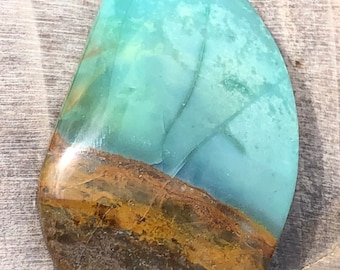 May include: A teardrop-shaped cabochon of blue-green opal with brown and orange banding. The opal is polished and has a smooth, glossy finish.