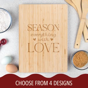 May include: A bamboo cutting board with the words "SEASON everything with LOVE" engraved on it. The image also includes bowls of flour and brown sugar, measuring spoons, wooden spoons, and eggs.