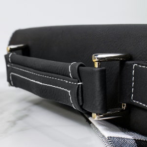 May include: Black leather carrying case with a white stitched handle and silver metal clasps.