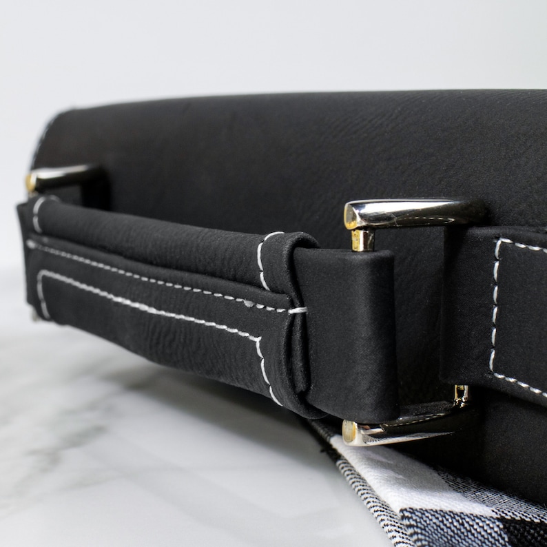 May include: Black leather carrying case with a white stitched handle and silver metal clasps.