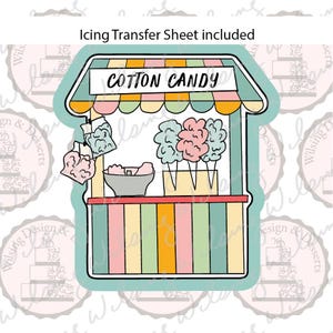 May include: A cookie cutter shaped like a cotton candy stand with a striped awning, a sign reading COTTON CANDY, and illustrations of cotton candy on sticks. The frame is teal, and an icing transfer sheet is included with the product.