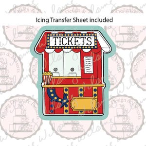 May include: A red and yellow ticket booth cookie cutter with a teal outline. The design features a sign that reads TICKETS, a popcorn bucket, and a blue arrow. The text Icing Transfer Sheet included is displayed above the ticket booth illustration.