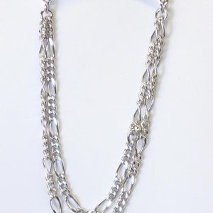 May include: Silver tie clip with a double chain design. The chain is made of two different styles of links, one is a simple oval link and the other is a more intricate design.