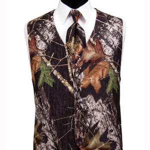 Puede incluir: Un chaleco de camuflaje marr&oacute;n, negro y verde con una corbata a juego. El chaleco tiene un cuello puntiagudo y un cierre de bot&oacute;n.