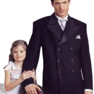 May include: A man in a black double-breasted suit with a white shirt and a white bow tie. He is standing next to a young girl in a white dress. The man is holding the girl's hand.