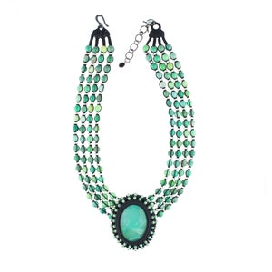 May include: A multi-strand necklace with green gemstone beads and a large oval green gemstone pendant.