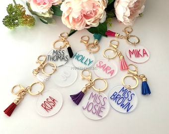 May include: Assortment of clear acrylic keychains with different names and colors. Each keychain has a gold ring and a tassel. The names on the keychains include "Miss Thomas", "Holly", "Sara", "Mika", "Rosa", "Miss Josie", and "Miss Brown".