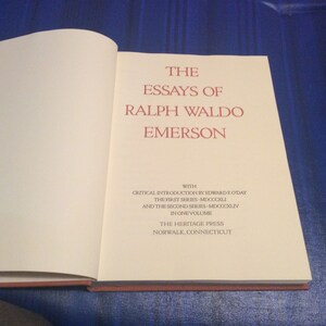 May include: The Essays of Ralph Waldo Emerson book cover with a white background and red text. The book was published by The Heritage Press in Norwalk, Connecticut. The first series was published in 1841 and the second series was published in 1844.