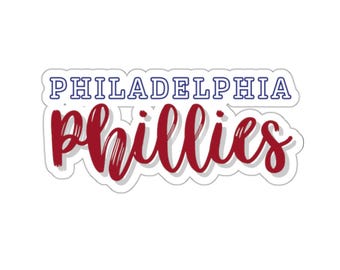 May include: A white sticker with the words "PHILADELPHIA" in blue and "Phillies" in red cursive lettering.