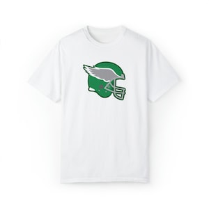 May include: White t-shirt with a green and gray football helmet graphic with a wing on the side.