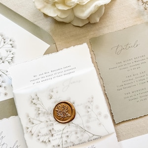 May include: A wedding invitation suite featuring sage green envelopes, deckle-edged paper, and a vellum overlay secured with a gold wax seal. The stationery includes printed baby's breath illustrations, black serif text, and a details card with event times.