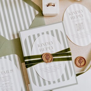 May include: A wedding stationery set featuring white and sage green striped cards, oval-shaped RSVP cards with QR codes, and a rectangular details card. The set is accented with dark green velvet ribbon and a gold wax seal with a floral design.