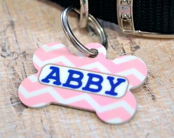 May include: Pink and white chevron dog tag with the name Abby in blue letters.