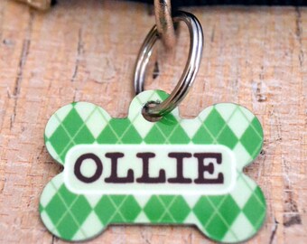 May include: Green and white bone-shaped dog tag with the name "OLLIE" printed in brown letters.